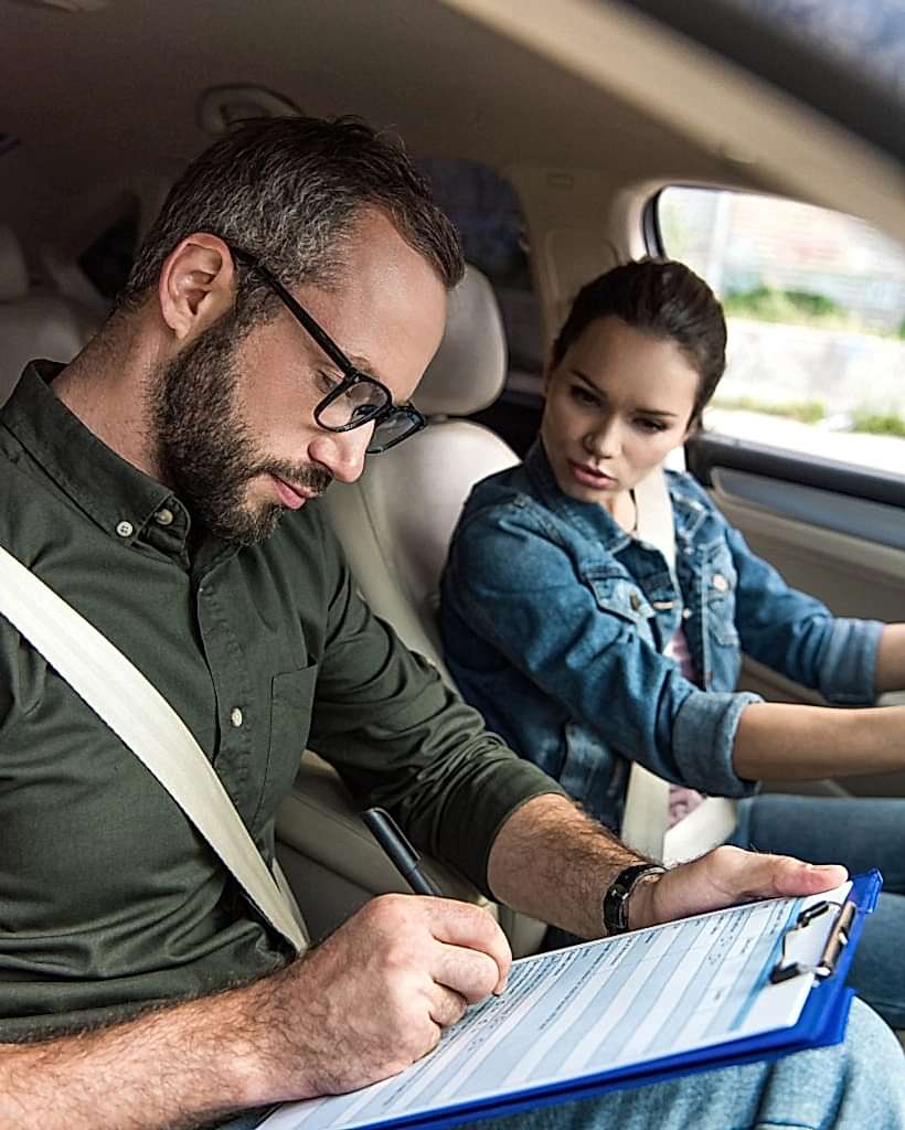 teacher-writing-something-to-clipboard-during-driving-test.jpg
